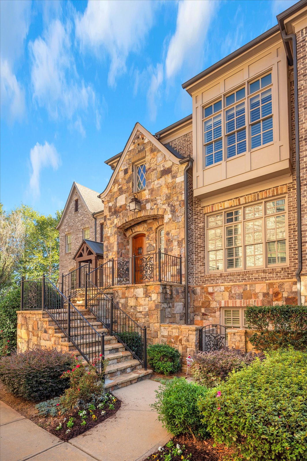 Warm stone and brick home with landscaped entry, from the authorized Stonehall collection