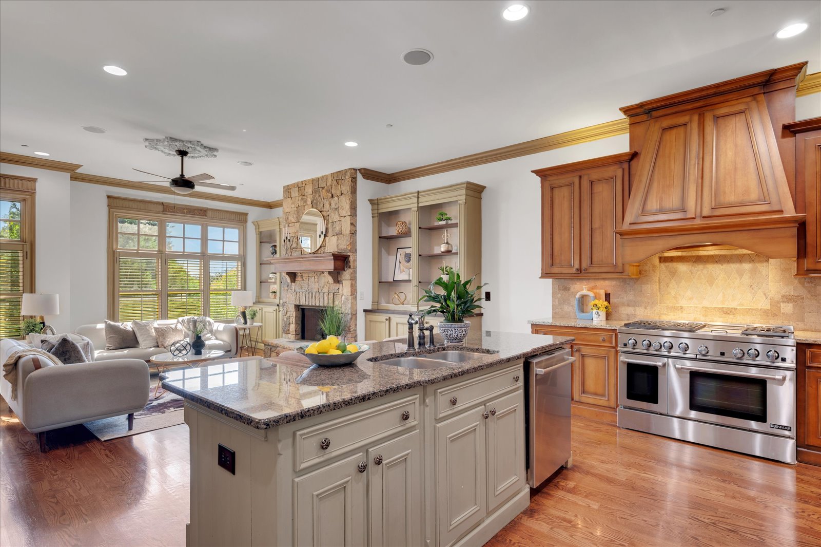 Kitchen with a painted island, warm wood cabinetry and an adjoining living room
